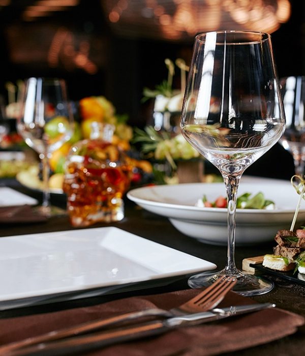 Table setting with snacks, glasses and a bottle of whiskey in the shape of a skull